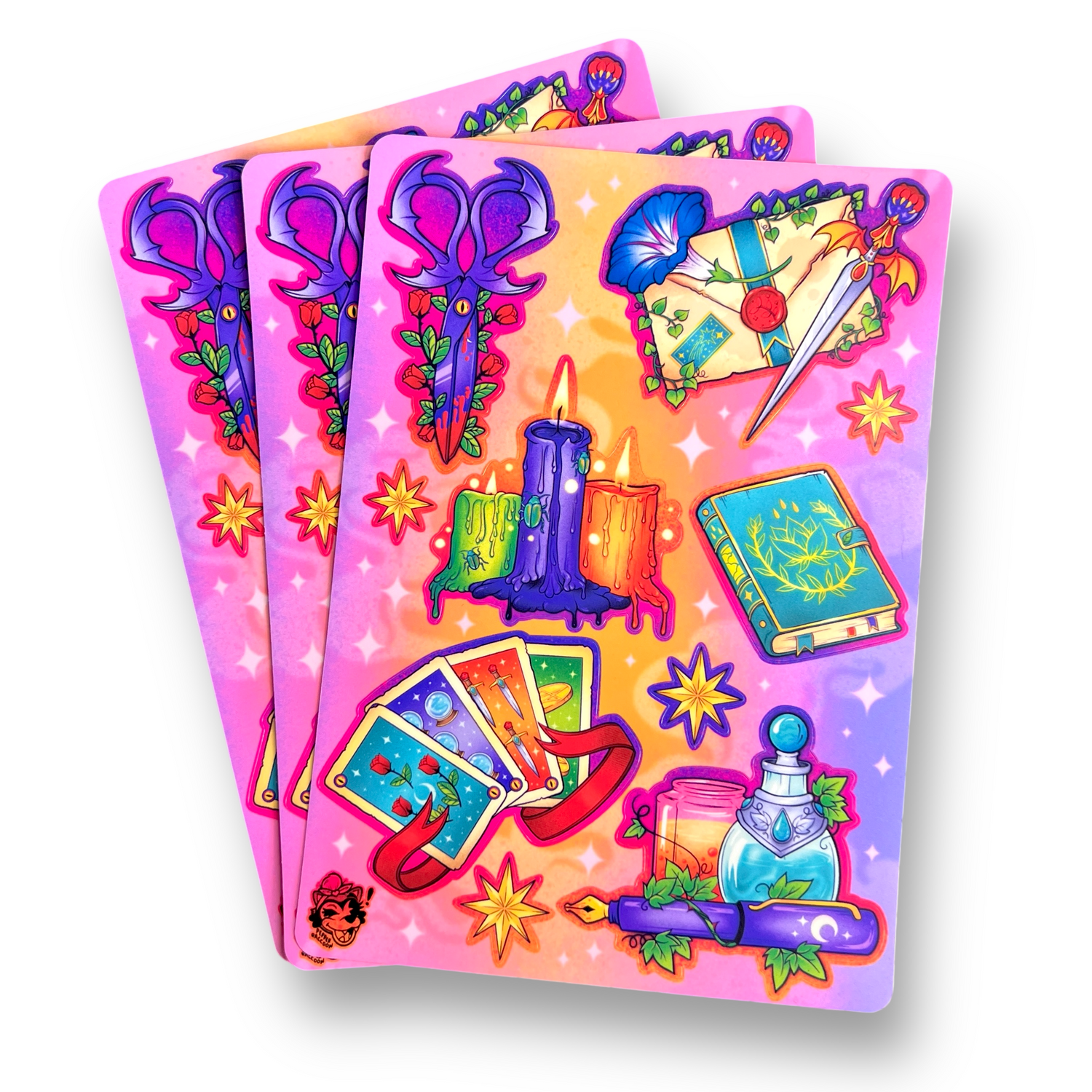 Three sticker sheets fanned out, featuring witchy designs of candles, bat scissors, tarot cards, potions, and more.