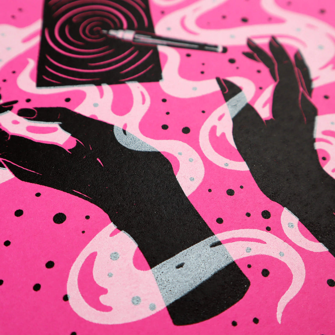 A close-up of a hot pink screenprinted artwork, with magical hands, floaty lines, and a piece of paper with a pen making designs on it.